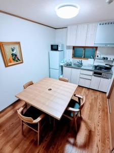 a kitchen with a wooden table and chairs at Oasis Aoto in Tokyo