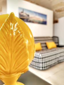 un vaso giallo seduto su un tavolo con un letto di La Casa di Pedro a Monopoli