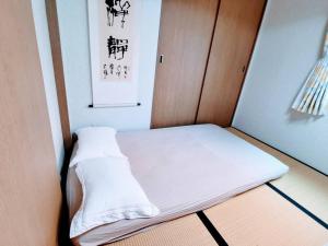 a small bed in a corner of a room at Oasis Aoto in Tokyo