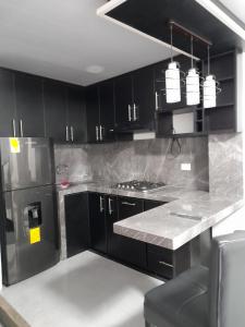 a kitchen with black cabinets and stainless steel appliances at Suite GomPal in Manta