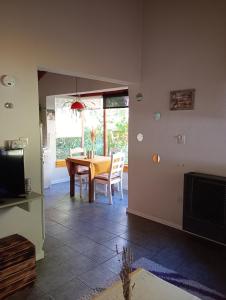 uma sala de jantar com mesa e cadeiras e uma televisão em Casa con jardín - Circuito Chico, Bariloche em San Carlos de Bariloche