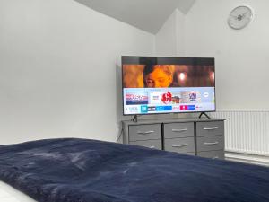 a bedroom with a flat screen tv on a dresser at Hometel Hidden Gem Large Comfy Home Can Sleep 13 in Braunstone