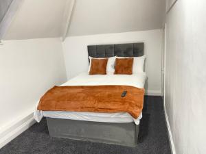 Hometel Hidden Gem Large Comfy Home Can Sleep 14 في Braunstone: غرفة نوم صغيرة مع سرير مع وسادتين