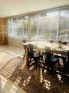 uma sala de jantar com uma mesa e cadeiras num tapete em Merrett Vale Home em Moss Vale
