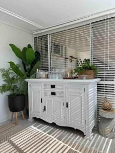 um armário branco com plantas num quarto em Merrett Vale Home em Moss Vale