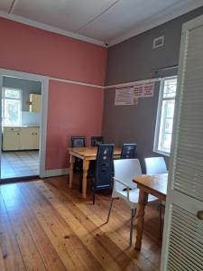 a dining room with wooden tables and chairs in a room at PMB Backpackers Lodge in Pietermaritzburg