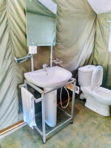 a bathroom with a sink and a toilet in a tent at Ella Glamping in Ella