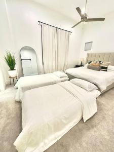 a white room with three beds and a ceiling fan at Comfortable Modern Home in Downtown Houston - Sleeps 10 in Houston