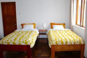2 Betten nebeneinander in einem Zimmer in der Unterkunft Inti Wasi II in Cusco