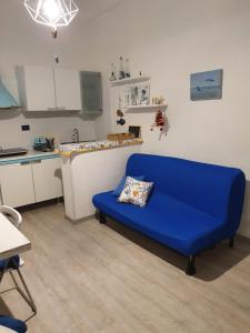 Appartamento a 100 metri dal mare في فرامورا: أريكة زرقاء في غرفة مع مطبخ