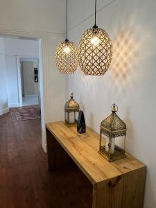 una mesa con dos linternas y dos luces en Harbour View Villa., en Mossel Bay
