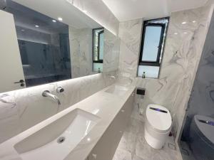 a white bathroom with a sink and a toilet at Shanghai Jing'an Modern Luxury Mansion 3 Bedrooms Near Metro & Attractions in Shanghai