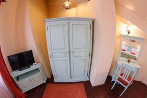 a large white cabinet with a tv and a tv at Pensiunea Adoro in Moieciu de Jos
