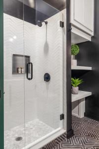 a shower with a glass door in a bathroom at Verdant Statuesque Intimate Acropolis Views Of Famous Park in Atlanta