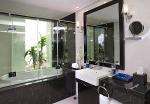 een badkamer met een wastafel en een grote spiegel bij Victor Gallery Hotel & Restaurant In Hanoi Old quarter in Hanoi