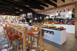 a restaurant with a long bar with stools at Sheraton Grand Tbilisi Metechi Palace in Tbilisi City