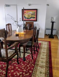 a dining room with a wooden table and chairs on a rug at Pips on Mitchell - Beautiful Historic Apartment in Bendigo