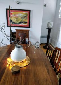 een vaas op een houten tafel met verlichting erop bij Pips on Mitchell - Beautiful Historic Apartment in Bendigo