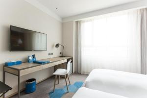 a bedroom with a desk with a television and a bed at Airline Inn - Kaohsiung Station in Kaohsiung