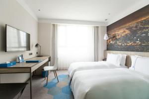 a hotel room with two beds and a desk at Airline Inn - Kaohsiung Station in Kaohsiung