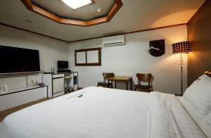 a hotel room with a bed and a tv at Buantreehotel Blackhouse in Buan