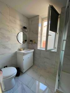 een badkamer met een toilet, een wastafel en een spiegel bij Studio Marseille centre in Marseille