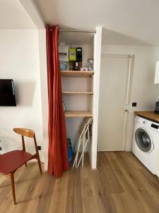 ein kleines Zimmer mit einer Waschmaschine und einem roten Vorhang in der Unterkunft Studio Marseille centre in Marseille