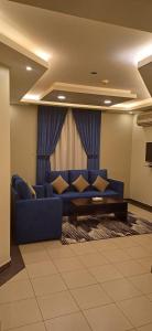 a living room with a blue couch in front of a window at ريف الخرج 2 للشقق الفندقية in Al Kharj