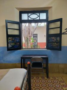 ventana en una habitación con mesa y silla en Hostal La Ermita, en Mérida