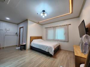 A bed or beds in a room at Wind Jeju Cafe & Pension