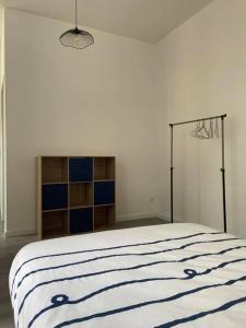 um quarto com uma cama com um cobertor azul e branco em Le Navy Blue em Vesoul