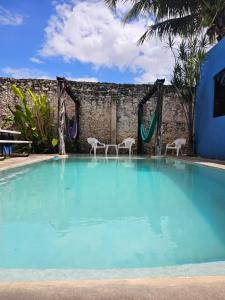 uma grande piscina com duas cadeiras e um baloiço em Hostal La Ermita em Mérida