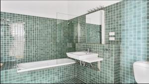 a green tiled bathroom with a sink and a tub at Pips on Mitchell - Beautiful Historic Apartment in Bendigo