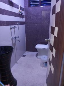 La salle de bains est pourvue de toilettes, d'un lavabo et d'une porte. dans l'établissement The Royal Scout Homestay, à Changar Talai