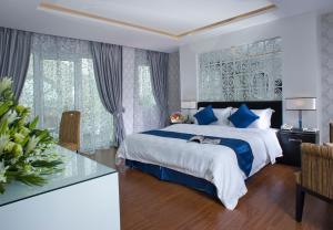 a bedroom with a large bed with blue pillows at Victor Gallery Hotel & Restaurant In Hanoi Old quarter in Hanoi