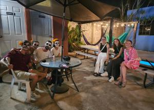 Hostal La Ermita في ميريدا: مجموعة من الناس يجلسون حول طاولة تحت مظلة