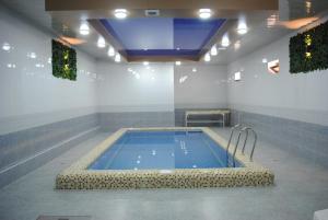 a large swimming pool in a room with a ceiling at Poykent Naqshband in Bukhara