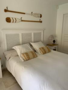 a white bed with two pillows on top of it at Suite dans un petit paradis in La Londe-les-Maures