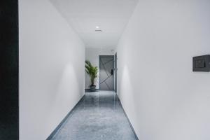 a hallway with white walls and a door at FabHotel Prime Cloud 5 Studios in Madhapur