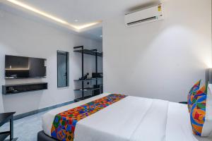 1 dormitorio con 1 cama y TV de pantalla plana en FabHotel Prime Cloud 5 Studios en Madhapur
