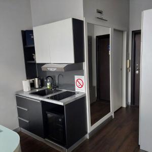 a small kitchen with a sink and a mirror at Passion Downtown Suite in Belgrade