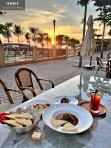 uma mesa com um prato de comida e batatas fritas em HANZ Lagoon Sunset Boutique Hotel em Duong Dong