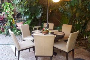 ニューオーリンズにあるTropical OASIS Getaway with a Private Pool & Spaのパティオテーブル、椅子、テーブル、椅子が備わります。