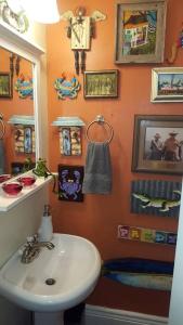 a bathroom with a white sink and a mirror at Tropical OASIS Getaway with a Private Pool & Spa in New Orleans