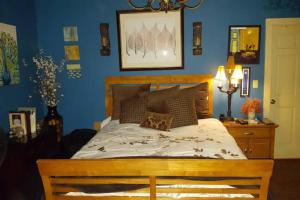 a bedroom with a large bed with blue walls at Tropical OASIS Getaway with a Private Pool & Spa in New Orleans