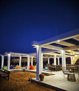 a pavilion with tables and chairs on the beach at night at SAMA Al Areesh Camp in Al Qābil