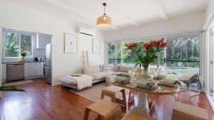 a living room with a couch and a table at Wollumboola Lake House in Culburra Beach