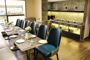 een restaurant met tafels en stoelen en een keuken bij Maxxvalue Hotel MIDC - Andheri in Mumbai