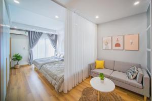 a bedroom with a bed and a couch and a table at TMS View Trực Diện Biển in Quy Nhon
