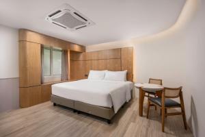 a bedroom with a bed and a table and a chair at The Bayou Hotel Langkawi in Pantai Cenang